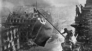 Soldaten hissen die sowjetische Flagge auf dem Reichstag &uuml;ber dem zerbombten Berlin. Ein ikonisches Bild vom Ende des Zweiten Weltkriegs.