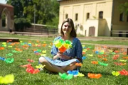 Die Künstlerin Iza Karaszewska sitzt in ihrer Kunstinstallation, einer Wiese mit über 1000 Blumen in Toruń, Polen. Jede Blume ist aus weggeworfenen Plastikflaschen handgefertigt.