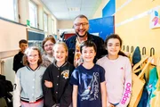 ZDFbesseresser Sebastian Lege steht inmitten von Schülerinnen und Schülern der Wilhelm-Lehmbruck Grundschule in Dorsten.