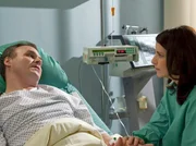 Reinhold Wollenberg (Oliver Breite, liegend) und seine Frau Andrea (Stefanie Höner) sprechen sich nach der OP aus und Reinhold versteht Andreas Wunsch nach einem Kind.