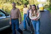 Aiden (Dara Devaney, l.), der Vater von Maeve (Skye McClenaghan, r.), will seiner Tochter, Bea (Aoife Hughes, 2.v.r.) und Alice (Scarlett Rayner, 2.v.l.) etwas zeigen. Er hat in der Vergangenheit einige Beweismittel gesammelt, die zeigen, dass die verschwunden Jugendlichen bereits in ihrer Kindheit miteinander verbunden waren. Finn (Jordan Adene, h.) versucht währenddessen, das Auto wieder fit zu machen.