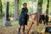 Nach der Beerdigung von Lukas König richtet Davis Mutter, Janaína Cruz (Denise M'Baye), ein umgestoßenes Holzkreuz an einem Grab wieder auf.