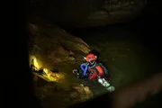 Ein Mann taucht in eine Höhle.