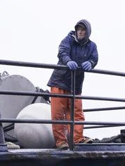 Southern Wind deckhand Steven leaning on the rail at the bow of the boat.