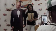 In Burkina Faso posiert eine junge Frau mit einer Pappfigur von Russlands Präsident Wladimir Putin.