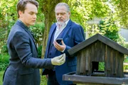 Im Bild: Tom Kupfer (Ludwig Blochberger, l.) und Hauptkommissar Richard Voss (Jan-Gregor Kremp) finden im Garten der Toten ein verbranntes Vogelhäuschen.