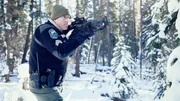 Officer Dan Christensen pointing a gun in the woods. Officer Dan Christensen pointing a gun in the woods.