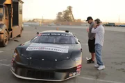 Brad DeBerti takes a seat in a stock car as his crew Ron Davis and Nick Joanides look on.