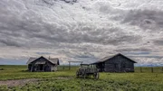 Zwei Häuser und eine Kutsche auf einer Ranch
