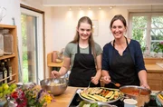 Gastgeberin Sylvia Geldmacher mit Tochter Charlotte (l). Sie bereiten gefüllte Zucchini und Kartoffeln im Speckmantel für den Hauptgang des Menüs.