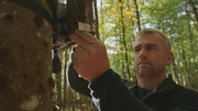 Ranger Jens Schlüter bei der Kontrolle von Soundboxen, die die Geräusche des Waldes aufzeichnen.