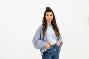 Moderatorin Ella führt die Teams Digital und Real durch die Challenges in der zweiten Staffel von Digiclash Der Generationen-Contest.