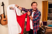 Gregor (Holger Matthias Wilhelm) schaut sich enttäuscht Veras Hochzeitsoutfit an.