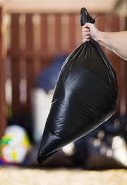 A Man taking out the trash in the back alley