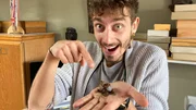 Jason mit einer Käferlarve auf der Hand.