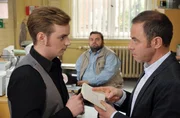 Jonas Wolter (Jan Niklas Berg, l.) und Hauptkommissar Kleinert (Felix Eitner, r.) diskutieren im Beisein von Ollie (Christoph Hagen Dittmann, M.) die Bankdaten des Yogastudios.