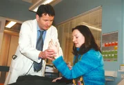 Dr. Roland Heilmann (Thomas Rühmann) bemerkt das auffällige Zittern an der Patientin (Gudrun Gabriel) und schöpft einen schlimmen Verdacht.