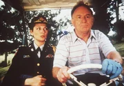 Im Golfcar unterwegs, obwohl sie ganz andere Sorgen haben: Major Sally McGill (Suzanne Lederer, l.) und General Garrett (Michael Currie, r.) ... Im Golfcar unterwegs, obwohl sie ganz andere Sorgen haben: Major Sally McGill (Suzanne Lederer, l.) und General Garrett (Michael Currie, r.) ...