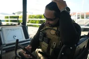 Ein CBP-Agent schaut auf einem Wasserfahrzeug in Mayaguez, P.R., auf sein Telefon.