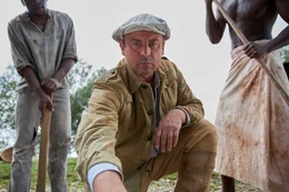 Dem Ingenieur Bernhard Sattler (Eckhard Preu&szlig;, Mi.) zeigen afrikanische Helfer (Uche Herbert, li., und Emmanuel Edigin, re.) gewaltige, versteinerte Knochen: der Beginn einer der erfolgreichsten Expeditionen in der Geschichte der Pal&auml;ontologie (Spielszene)