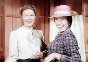 Mrs. Oleson (Katherine MacGregor, r.) gratuliert Caroline (Karen Grassle, l.) zur Erbschaft ihres Mannes.