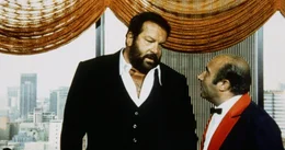 SzenenbildUm in einem Mordfall weiterzukommen, verschl&auml;gt es den schlagkr&auml;ftigen Polizeikommissar Rizzo (Bud Spencer, l.) nach Johannesburg, wo er auf seinen alten Freund Caputo (Enzo Cannavale, r.) trifft ...