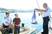 Jakob Frings (Max König, li.) wartet gespannt auf die Erklärung des Schmuckhändlers Florian Arlen (Carsten Strauch, M.) zu dem Fund, den sein Kollege Paul Schott (Tim Wilde, r.) soeben aus dem Wasser gefischt hat.