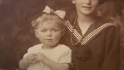 Ella und Fanni schauen sich gemeinsam mit ihrer Großmutter alte Fotoalben an.