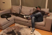 Host Antonio Ballatore sits on the couch with the large python.