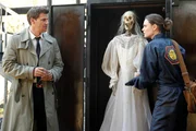Booth (David Boreanaz, L) and Brennan (Emily Deschanel, R) examine a skeleton