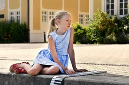 Lotte (Delphine Lohmann) spielt lieber Klavier als mit den anderen Kindern im Wasser.
