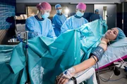 Die Ärztinnen Julia Berger (Mirka Pigulla, l.) und Karin Patzelt (Marijam Agischewa, 2.v.r. mit Komprsin, h.) operieren den verletzten Arm der jungen Patientin Vittoria Saltini (Mila Böhning, r.) Die Ärztinnen Julia Berger (Mirka Pigulla, l.) und Karin Patzelt (Marijam Agischewa, 2.v.r. mit Komprsin, h.) operieren den verletzten Arm der jungen Patientin Vittoria Saltini (Mila Böhning, r.)