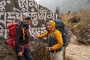 Nepal ist ein Land mit kulturellem und religiösem Reichtum. Ben Matern (r.) wandert mit Anand Sharma (l) durch die buddhistisch geprägte Region der Sherpas. Hier schreiben Menschen Mantras und Gebete auf Felsen.