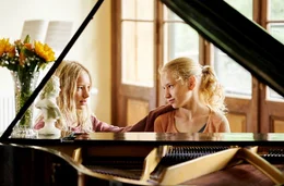 Lotte (Delphine Lohmann, rechts) spielt Luise (Mia Lohmann) auf dem Klavier vor.