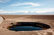 Wie ein riesiger Spiegel erscheint der kreisrunde See inmitten der Atacama-Wüste in Chile. Er gehört zu den beiden „Augen der Wüste“, den Ojos del Salar – Süßwasserseeen inmitten der trockenen Salzpfanne. Wie ein riesiger Spiegel erscheint der kreisrunde See inmitten der Atacama-Wüste in Chile. Er gehört zu den beiden „Augen der Wüste“, den Ojos del Salar – Süßwasserseeen inmitten der trockenen Salzpfanne.