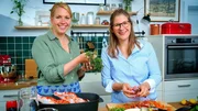 Beim Kochen wird Gastgeberin Anna (l.) von ihrer Freundin Wiebke (r.) unterstützt.