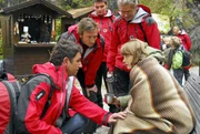Dr. Martin Gruber (Hans Sigl, li.) und sein Bruder Hans (Heiko Ruprecht, 2.v.li.) versuchen, Andrea (Laura Tonke, re.) zu beruhigen, deren Schwester gerade in einer Höhle tödlich verunglückt ist.