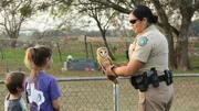 Warden Wei Wei Startz holding an owl and talking to kids.