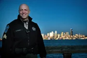 Officer Olson standing in front of a skyline.