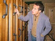 Willi Weitzel begutachtet in der Sargschreinerei Stöckl verschiedene Sargdeckel.