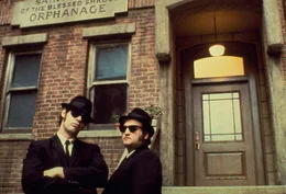 Schwarze Anz&uuml;ge, schwarze H&uuml;te, schwarze Sonnenbrillen und nat&uuml;rlich ein schwarzes Auto - so ziehen die Br&uuml;der Jake (John Belushi, r.) und Elwood Blues (Dan Aykroyd, l.) durch Detroit und hinterlassen eine Spur der Verw&uuml;stung hinter sich ...