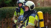 Zwei Feuerwehrleute am Einsatzort in Dresden.
