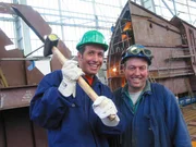 Zusammen mit einem Mitarbeiter der Nordseewerke erkundet Willi (links) die Emdener Schiffswerft.