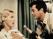 Leutnant Evans (Tony Curtis) versucht sich bei Barbara (Dina Merrill) mit erstklassigem Champagner lieb Kind zu machen.