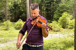 Geigenbauer Rubino Gabrielli probiert seine Geige im Resonanzwald aus.
