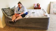 Brianne sits on bed