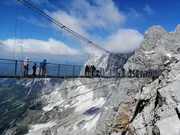 Abenteuer Alpen: eine gigantische Hängebrücke unter dem Dachstein-Gipfel, mit 2995 Metern Höhe das höchste Bergmassiv der österreichischen Bundesländer Oberösterreich und Steiermark.