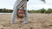 Charlotte ist froh, wenn sie im Sand Radschlag macht. Charlotte ist froh, wenn sie im Sand Radschlag macht.