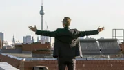 Schauspieler Matthias Matschke als "Immobilienhai" &uuml;ber den D&auml;chern einer Gro&szlig;stadt.