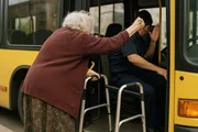 An elderly lady with a walker involved in an incident with a bus driver